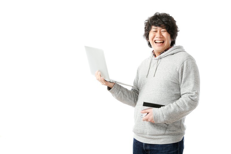 ノートパソコンを片手に笑顔の男性