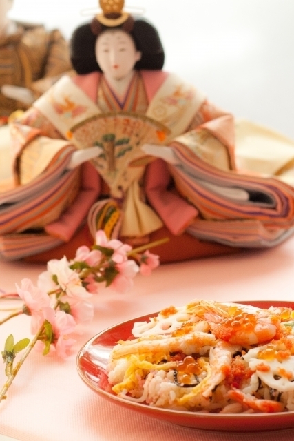 雛人形と桃の花と具がたっぷりのちらし寿司