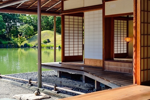 古い日本家屋の廊下から見える庭の池