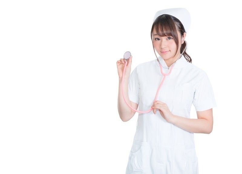 聴診器を片手に持つ看護師の女性