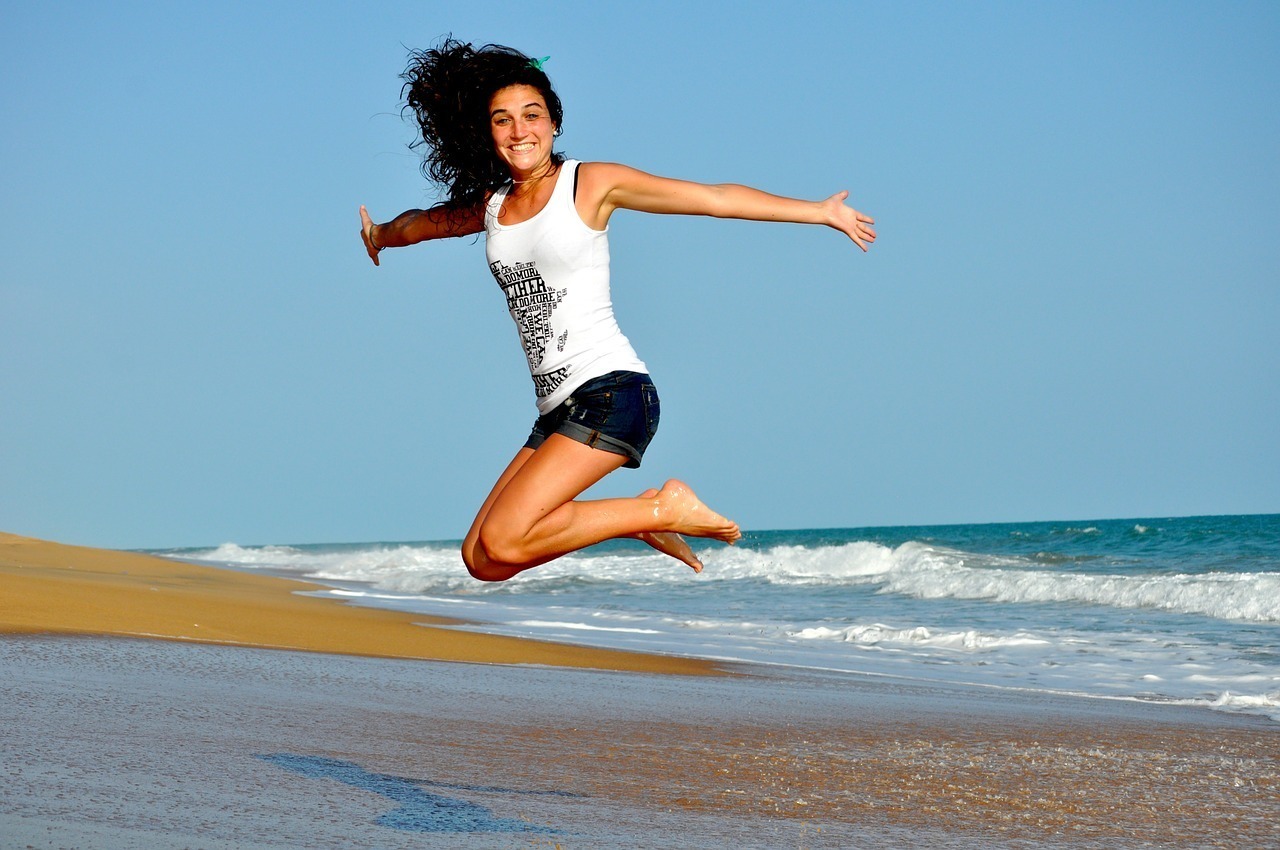 海辺でジャンプする女性